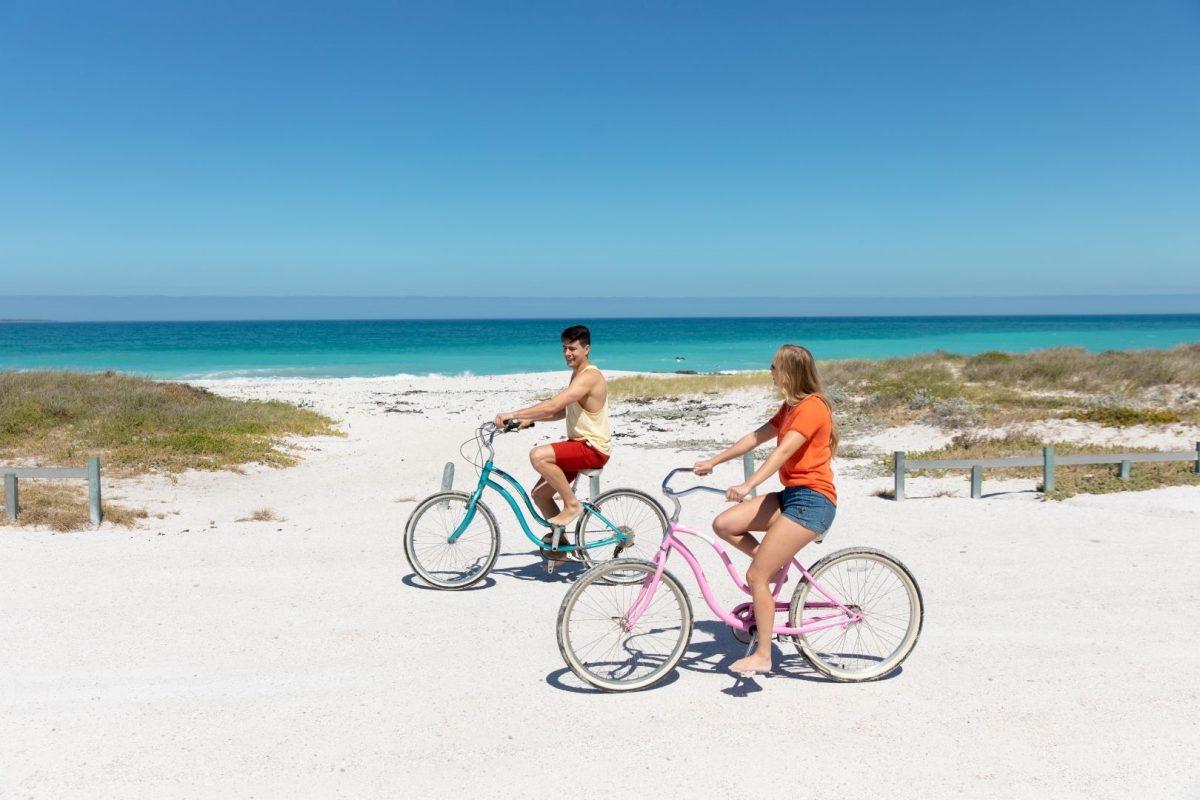 couple riding bikes by the beach